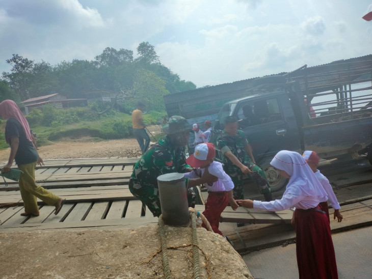 Tim Satgas TMMD Bantu Anak Sekolah Menyeberangi Sungai: Kasih Sayang dan Kepedulian untuk Anak anak Bangsa. 